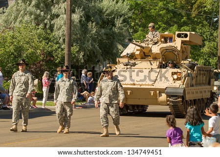 MIDDLETON, IDAHO - JULY 4: US army walking down the street in front of a M2 fighting infantry vehicle on 4th of July celebration in Middleton, Idaho July 4 2012
