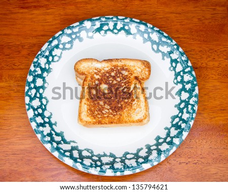 Piece of toast that is part of a grilled cheese sandwich.