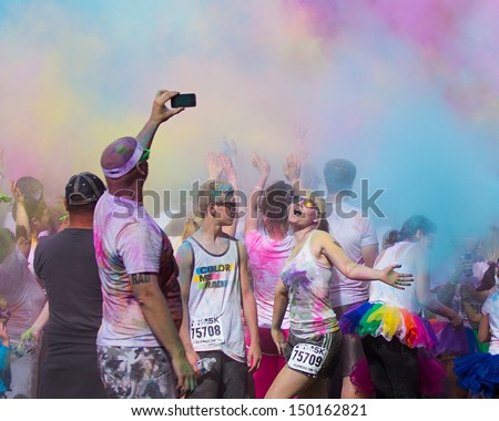 BOISE, IDAHO/USA - JUNE 22: Unidentified man takes a photo of another runner and all the colors at the Color Me Rad 5k in Boise, Idaho on June 22, 2013