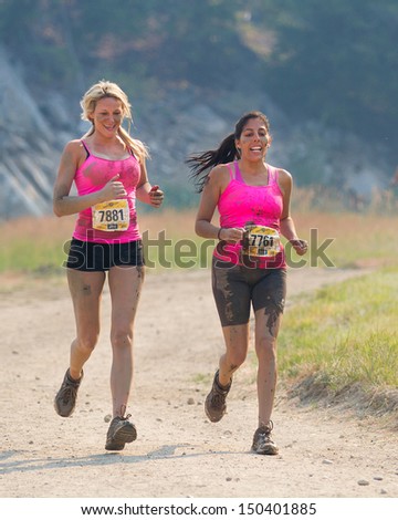 BOISE, IDAHO/USA - AUGUST 10: Runners 7881 and 7761 run down the dirt track at the The Dirty Dash in Boise, Idaho on August 10, 2013