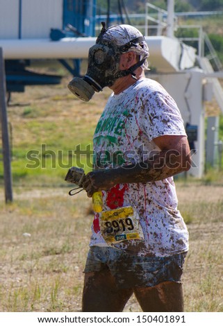BOISE, IDAHO/USA - AUGUST 10: Runner 8919 walks with his with his  gas mask on while competing at the The Dirty Dash in Boise, Idaho on August 10, 2013