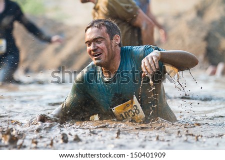 BOISE, IDAHO/USA - AUGUST 10: Unidentified man crawls through the mud at the The Dirty Dash in Boise, Idaho on August 10, 2013