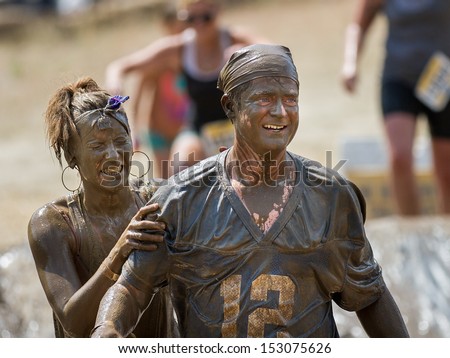 BOISE, IDAHO/USA - AUGUST 11: Two people covered in mud work their way to the finish line at the The Dirty Dash in Boise, Idaho on August 11, 2013