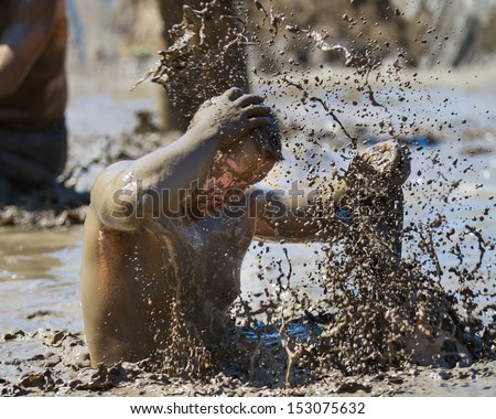 BOISE, IDAHO/USA - AUGUST 10: Unidentified man makes a splash with mud during the The Dirty Dash in Boise, Idaho on August 10, 2013