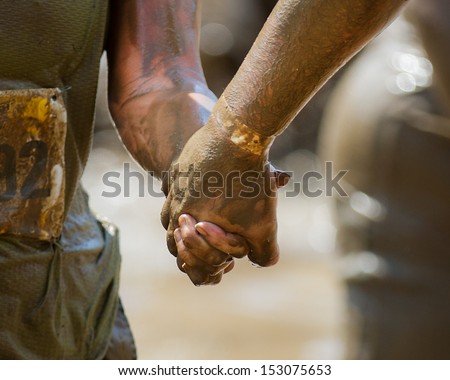 BOISE, IDAHO/USA - AUGUST 11: Couple hold hands while they work their way through the course at the The Dirty Dash in Boise, Idaho on August 11, 2013