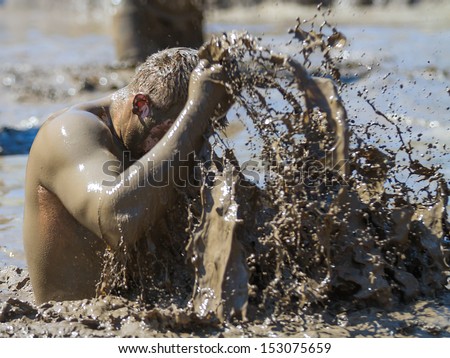 BOISE, IDAHO/USA - AUGUST 10: Unidentified man washes off using mud at the The Dirty Dash in Boise, Idaho on August 10, 2013