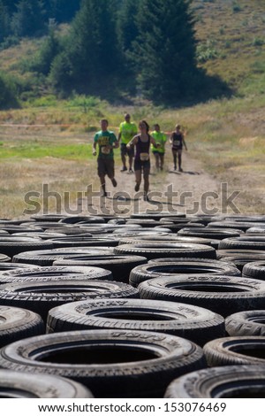 Boise, Idaho/Usa - August 10: Group Of Runners Race To The Tire Course At The The Dirty Dash In Boise, Idaho On August 10, 2013. Focus Is Shallow And Set On The Tires
