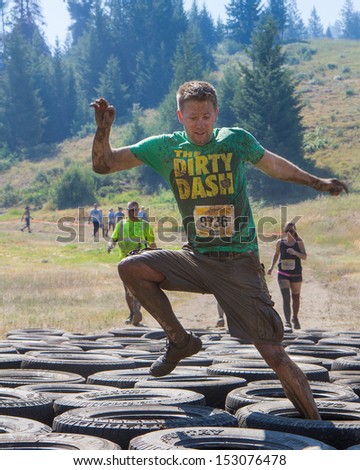 Boise, Idaho/Usa - August 10: A Runner With Bib Number 9736 Does Tries His Luck Through The Tire Obstacles At The The Dirty Dash In Boise, Idaho On August 10, 2013