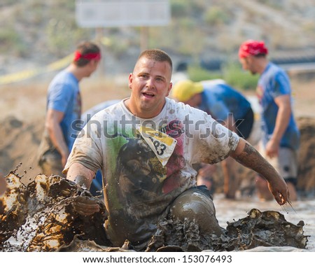 BOISE, IDAHO/USA - AUGUST 10: Unidentified man runs at top speed in the mud pit at the The Dirty Dash in Boise, Idaho on August 10, 2013
