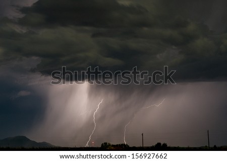Night time thunderstorm at work with a coupe of ground strikes. Image was shot at high iso and does have noise present.