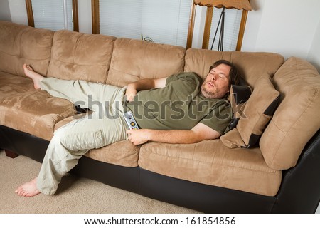 Fat Man Sleeping On The Couch With His Hand Down His Pants