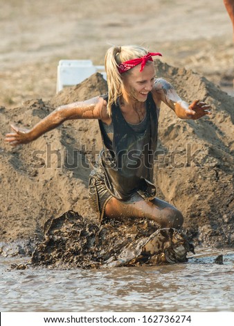 BOISE, IDAHO/USA - AUGUST 10:Unidentified woman smiles as she struggles through the mud pit  at the The Dirty Dash in Boise, Idaho on August 10, 2013