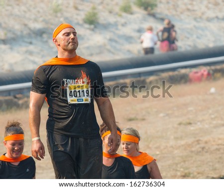 BOISE, IDAHO/USA - AUGUST 10: MAn 40119 stands with his superhero cape at the The Dirty Dash in Boise, Idaho on August 10, 2013