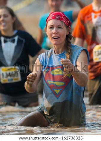 BOISE, IDAHO/USA - AUGUST 10: Woman dances near the finish line in the mud at the The Dirty Dash in Boise, Idaho on August 10, 2013