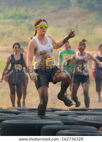 BOISE, IDAHO/USA - AUGUST 10: Runner 8852 leads the crowd through the tires at the The Dirty Dash in Boise, Idaho on August 10, 2013
