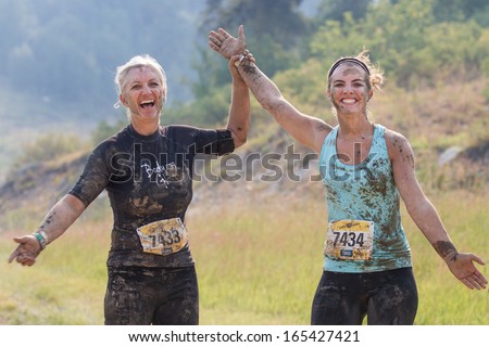 BOISE, IDAHO/USA - AUGUST 10: Two runners hold each others hands up in the air to pose at the The Dirty Dash in Boise, Idaho on August 10, 2013