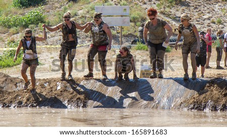 BOISE, IDAHO/USA - AUGUST 10:Team of runners about to jump into the pond of mud at the The Dirty Dash in Boise, Idaho on August 10, 2013