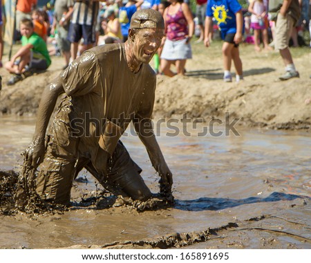 BOISE, IDAHO/USA - AUGUST 10: Man drips mud after standing up in the mud pit at the The Dirty Dash in Boise, Idaho on August 10, 2013