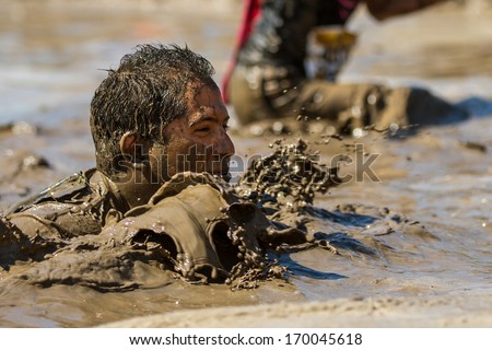 BOISE, IDAHO/USA - AUGUST 10, 2013: Unidentified swimmer works through the mud at the The Dirty Dash