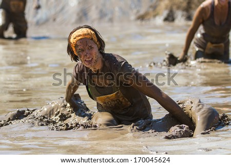 BOISE, IDAHO/USA - AUGUST 10, 2013: Unidentified runner makes a splash on her way through the mud at at the The Dirty Dash