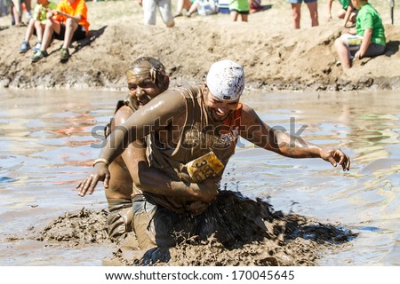 BOISE, IDAHO/USA - AUGUST 10, 2013: Runner 7358 tries to get away from someone making a big splash at the The Dirty Dash