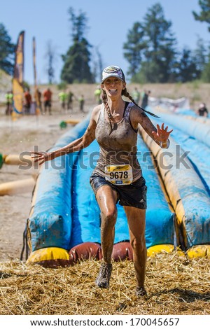 BOISE, IDAHO/USA - AUGUST 10, 2013: Runner 9678 just passed the slide and now runs to the mud pit at the The Dirty Dash