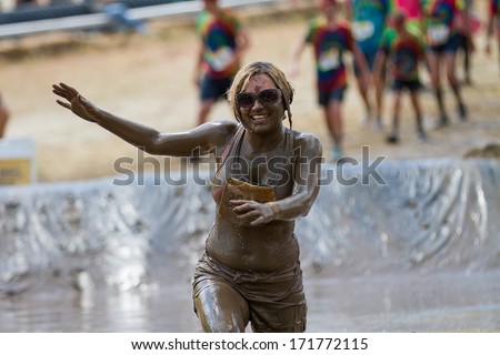 BOISE, IDAHO/USA - AUGUST 11, 2013: Unidentified woman tries to balance at the mud pit during the dirty dash