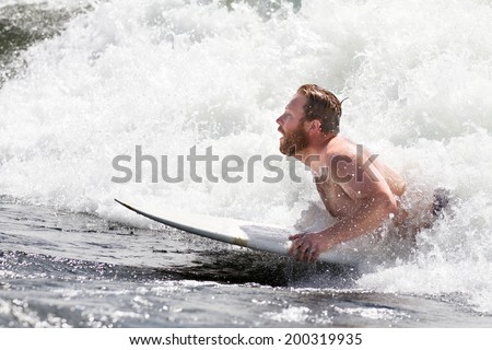 CASCADE, IDAHO/USA - JUNE 21, 2014: Boarder gets ready to get up to do some tricks out on the river during the Payette River Games