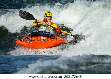 CASCADE, IDAHO/USA - JUNE 21, 2014: Young competitor works her kayak at the Payette River Games in Cascade, Idaho