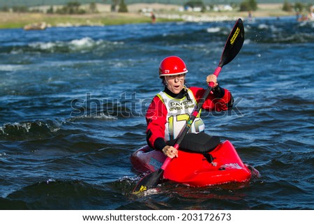 CASCADE, IDAHO/USA - JUNE 21, 2014: Waiting for her turn to go down the river a Kayaker relaxes in the water at the Payette River Games in Cascade, Idaho