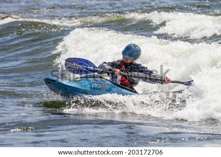 CASCADE, IDAHO/USA - JUNE 21, 2014: Trying to get his kayak around a young person has fun at the Payette River Games in Cascade, Idaho