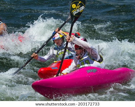 CASCADE, IDAHO/USA - JUNE 21, 2014: Two people racing their kayaks at the Payette River Games in Cascade, Idaho