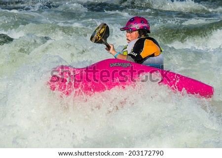 CASCADE, IDAHO/USA - JUNE 21, 2014: White water foaming this person stays up at the Payette River Games in Cascade, Idaho