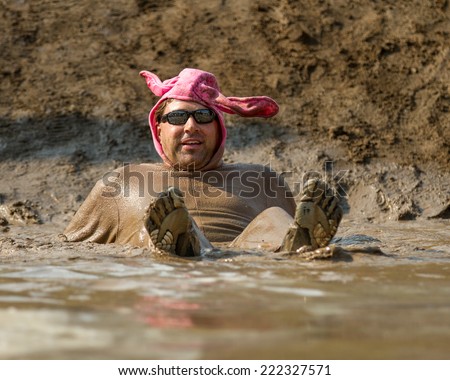 BOISE, IDAHO/USA - AUGUST 8, 2014: Unidentified man in a pig costume relaxing at the Dirty Dash in Boise, Idaho