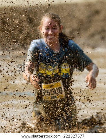BOISE, IDAHO/USA - AUGUST 8, 2014: Runner 25506 splashing mud at the Dirty Dash in Boise, Idaho. Focus is shallow and on the mud droplets