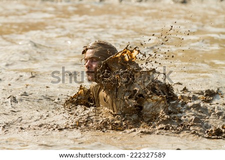 BOISE, IDAHO/USA - AUGUST 8, 2014: Unidentified swimmer is swimming through the mud pit near the finish at the Dirty Dash in Boise, Idaho