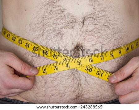Fat guy with a tape measure over his belly trying to measure his weight