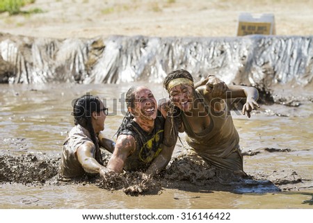 BOISE, IDAHO/USA - AUGUST 11, 2013: Group of women falling into the mud during the Dirty Dash in Boise, Idaho