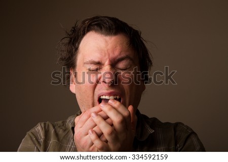 Man sneezing due to having a cold