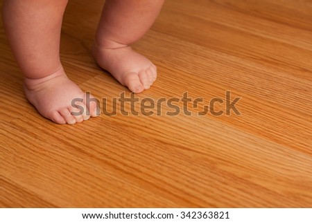 Little girl taking her first steps on some hardwood floor