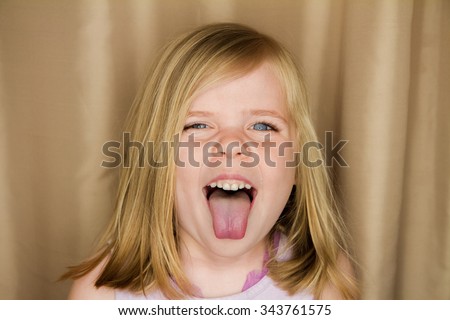 Young girl sticking her tongue out making a funny face