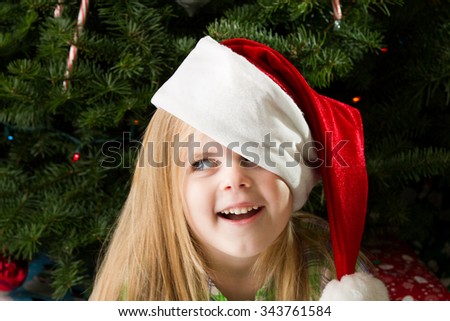 Girl enjoying her christmas presents and christmas hat