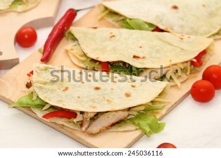 burrito - a fresh flat cake with chicken, sauce to a guakamola, vegetables