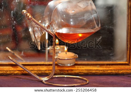glass and its reflection over fire at an old mirror