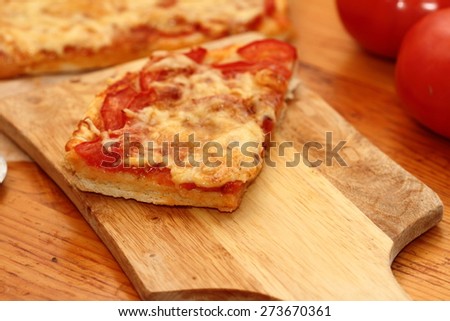 piece of pizza Margarita on a wooden chopping board