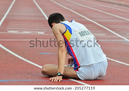 Sad athlete on the ground after loosing race