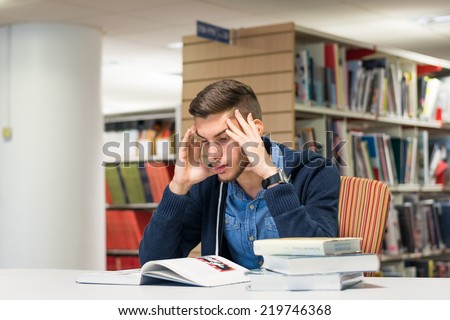 Stressed student doing research in the library and studying for exam. Education concept