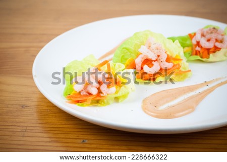 Fresh prawn or shrimp layered salad with Mary Rose dressing on a wood textured background. Healthy and tasty food recipe for a balanced nutrition.