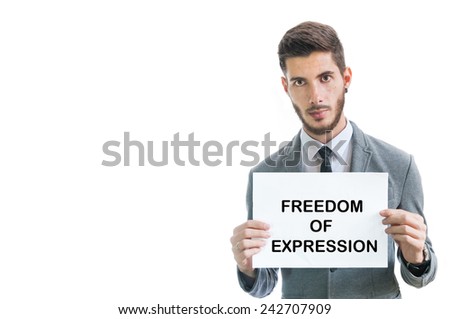 Freedom of expression sign held by man in grey suit as tribute for the newspaper attack in Paris, isolated on white with copy space for text.