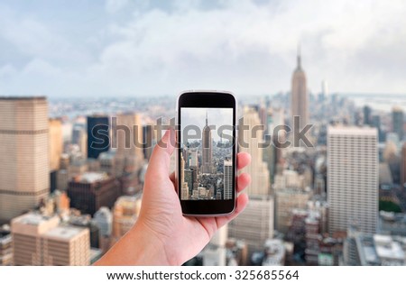 Hand with smartphone taken pictures of new york city skyline